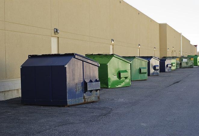 a pile of demolition waste sits beside a dumpster in a parking lot in Bridgeton